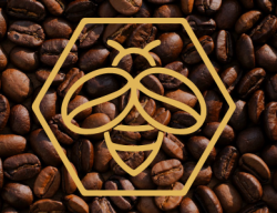 A yellow logo of a bee win a honeycomb is overlayed on an image of coffee beans