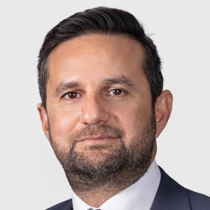 Portrait of a slightly bearded man in a suit and tie.