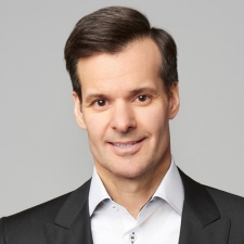 Smiling dark-haired man, wearing a white shirt and dark jacket