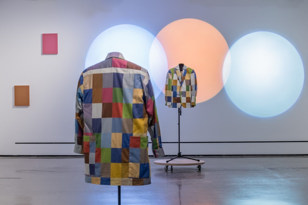Colorful checkered jacket on mannequin, abstract background.