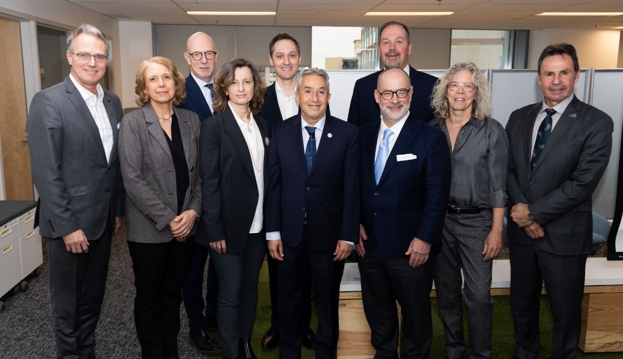 A group of professionals stand for a portrait in an office setting