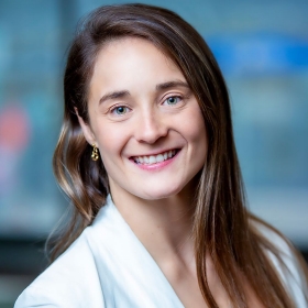  portrait of a smiling person in a white outfit with a softly focused background.