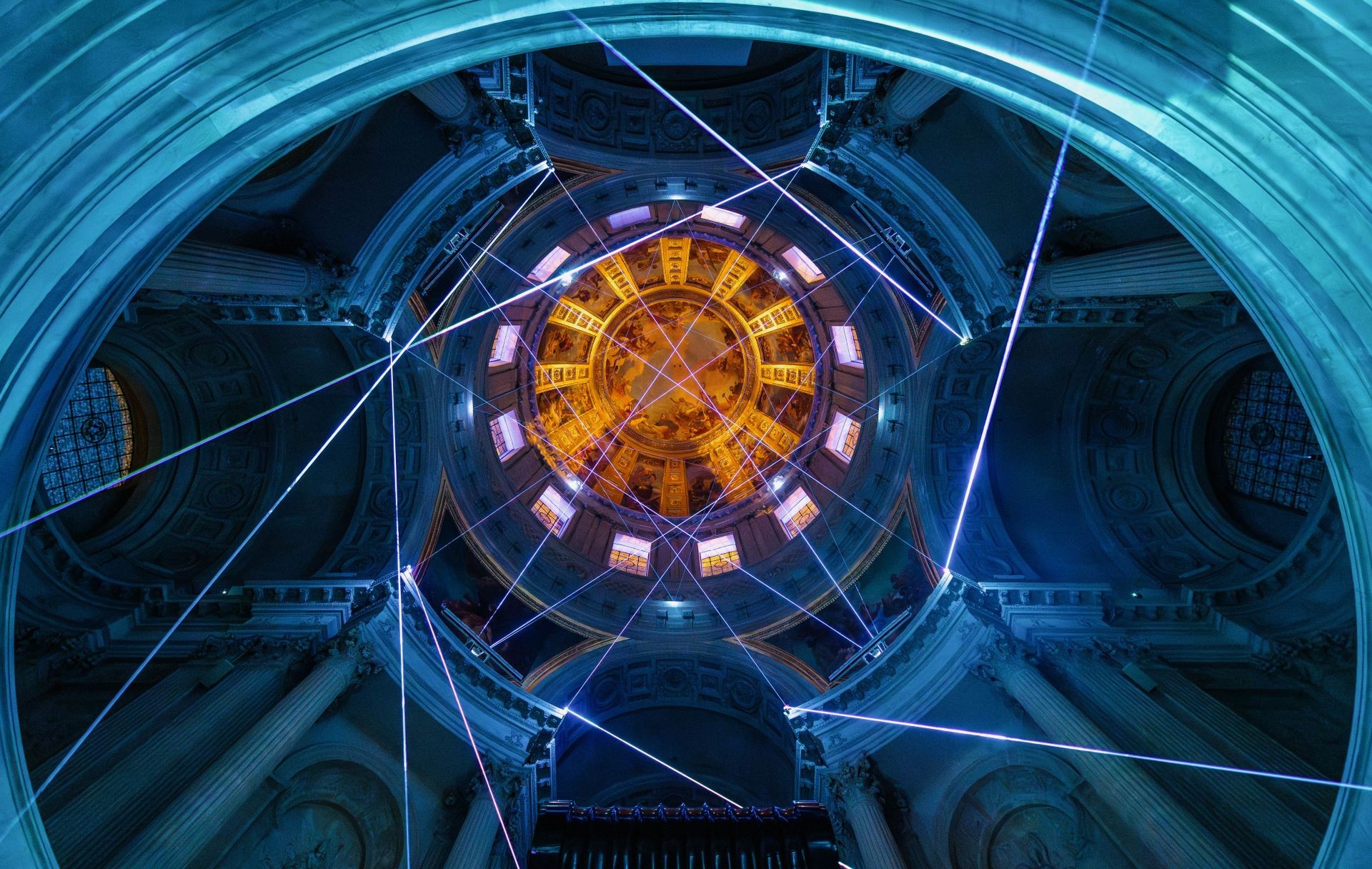 Blue lights and lasers surround the ceiling of Les Invalides in Paris