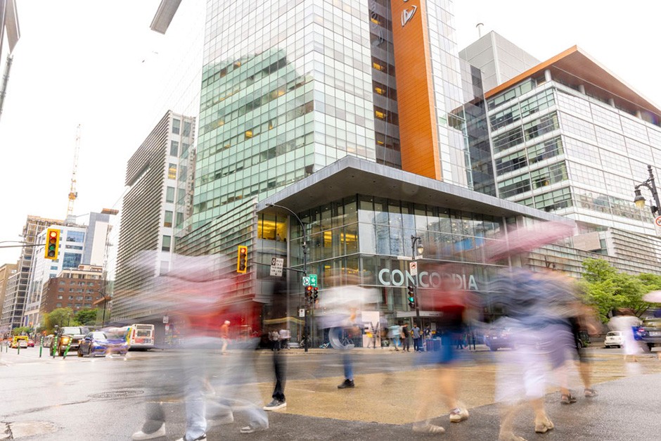 A view of the corner of St-Catherine and Guy streets with pedestrians walking by.