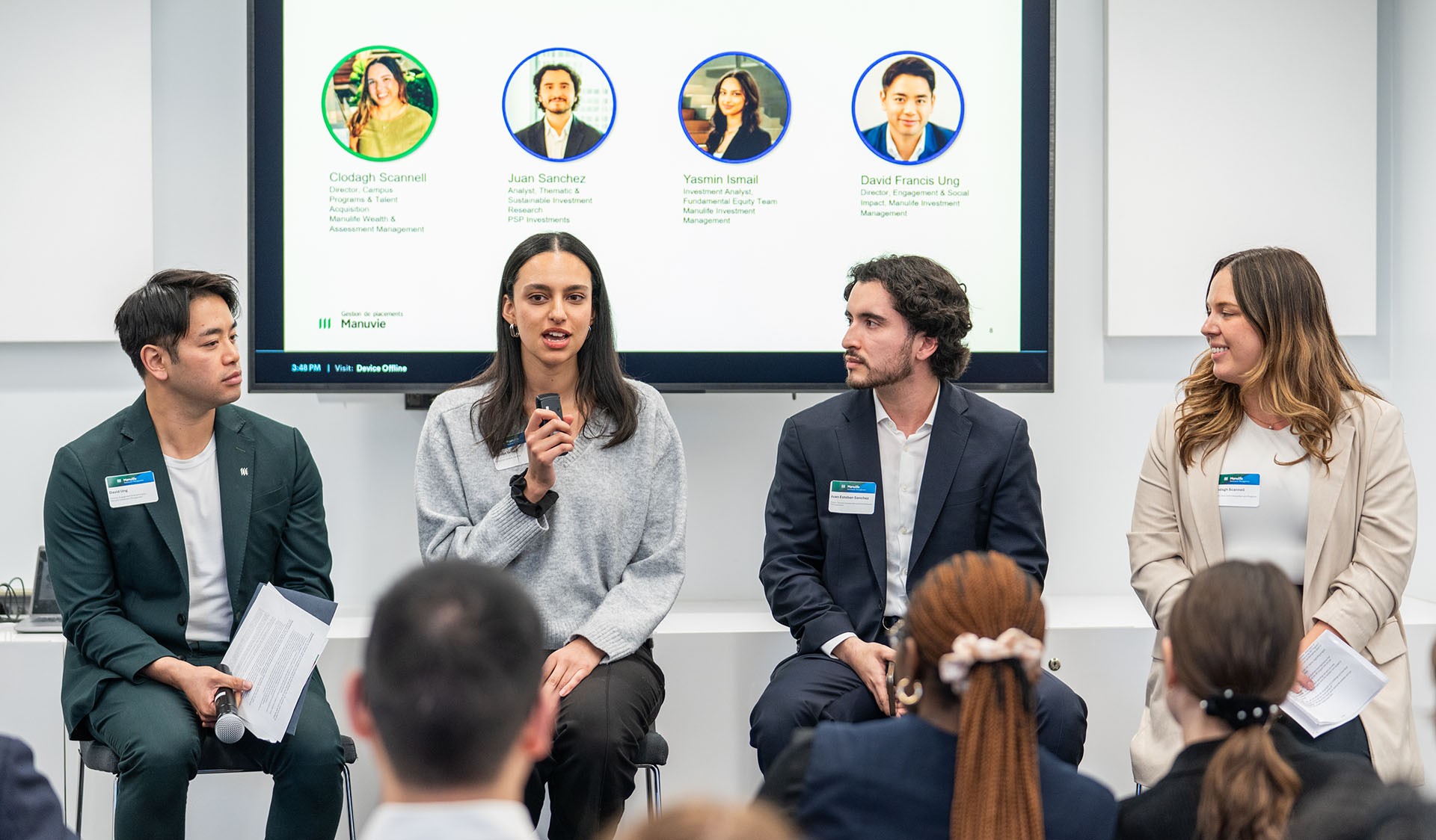 Four students lead a panel discussion infront of an audience.