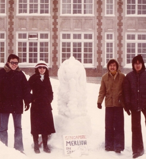 Four Concordia students stand next to a snow sculpture.