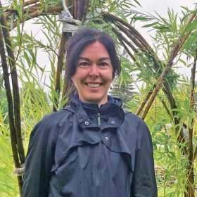 A portrait of Isabelle standing in a bamboo forest.