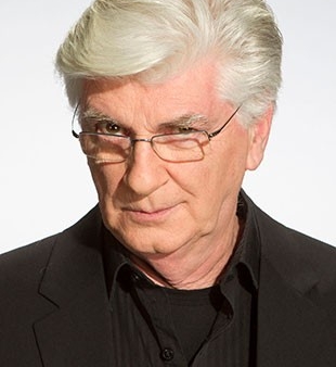 He has white hair and hazel eyes. He wears a black suit and thin, half-rim glasses.
