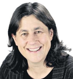 She has black hair and hazel eyes. She wears a black shirt and jacket.