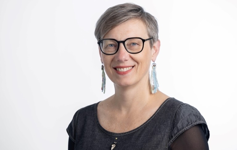 Meredith has short grey hair, glasses and wears a black top .