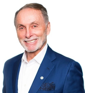 He wears a medium blue suit and a white shirt.