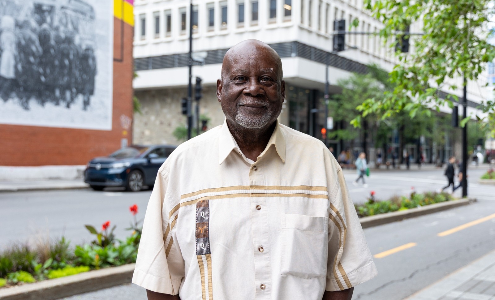 Fred Anderson stands outside of Concordia University's downtown campus and is wearing a cream-coloured shortsleeved button-down shirt.