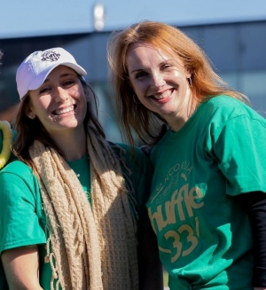 Three people standing together with green Shuffle t-shirts on. 