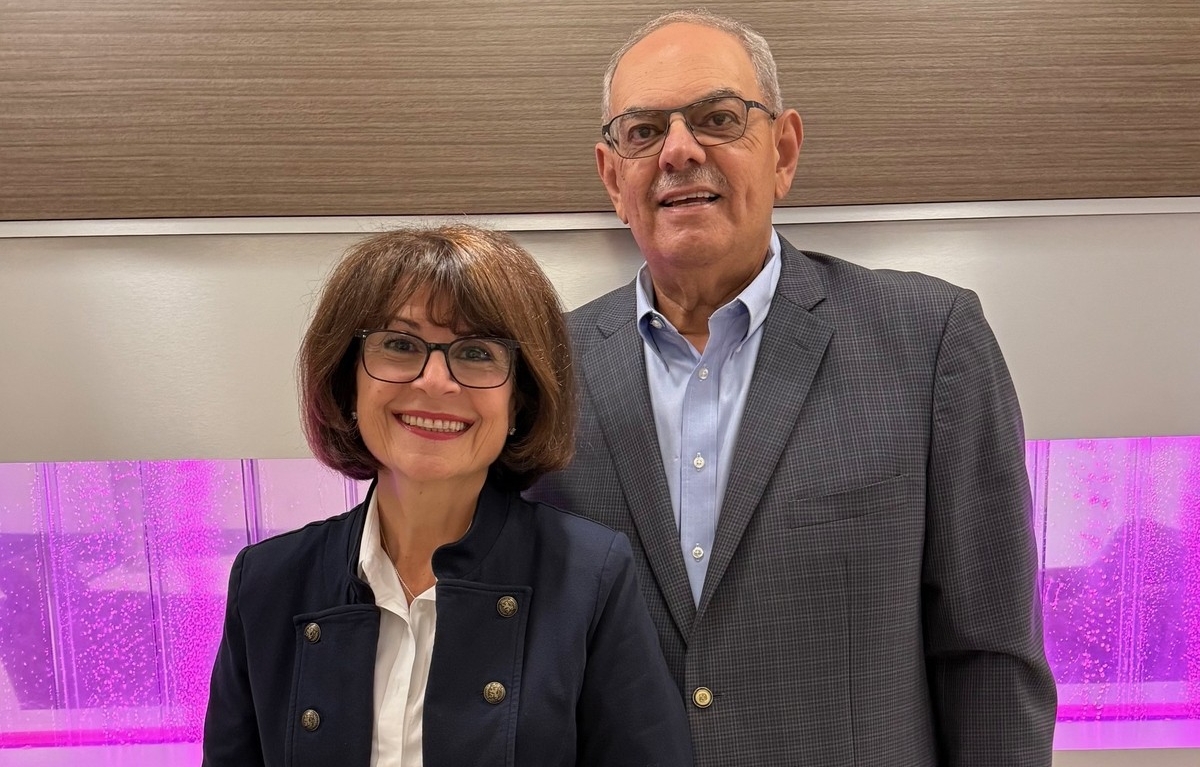 Laïla Ward Farag and Hani Farag are both wearing glasses and blazers and are smiling.