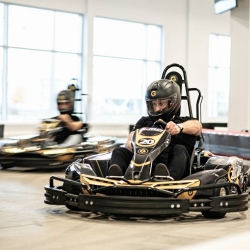 Person wearing helmet driving a go-kart