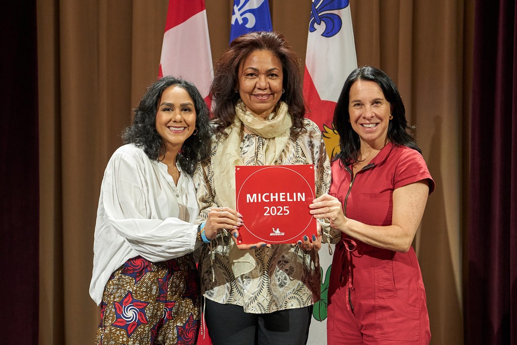 Three women hold up a sign that says Michelin 2025.