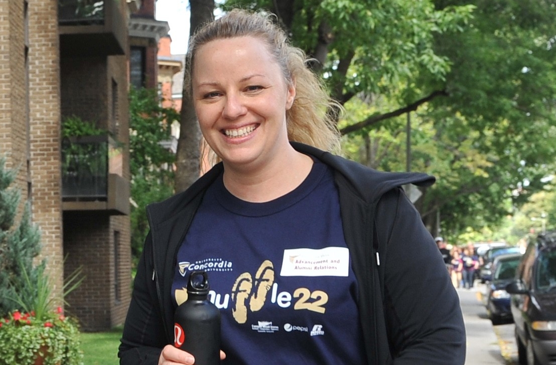 Danielle Duguay has blonde hair in a ponytail and is seen walking on a tree-lined street.