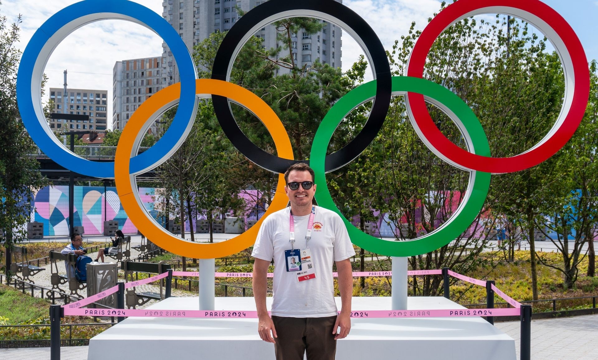 Romain stands in front of the Olympic rings in Paris.