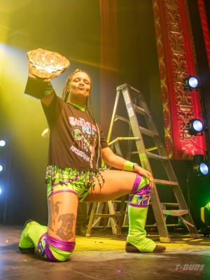Wrestler Kristara Napier-Davies holds up her championship belt.