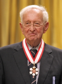 A man in a suit smiles and is wearing an Order of Canada medal.