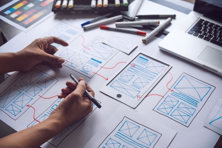 Hands working on UX wireframes