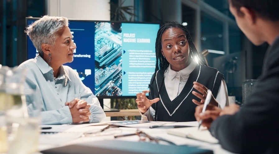 Three team members talk at work