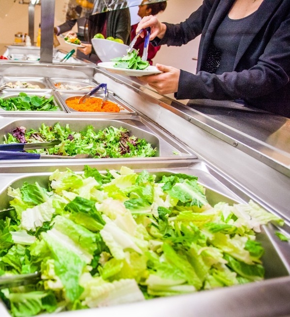 People filling their plates at a salad bar in the Dining Hall of the Grey Nun's residence