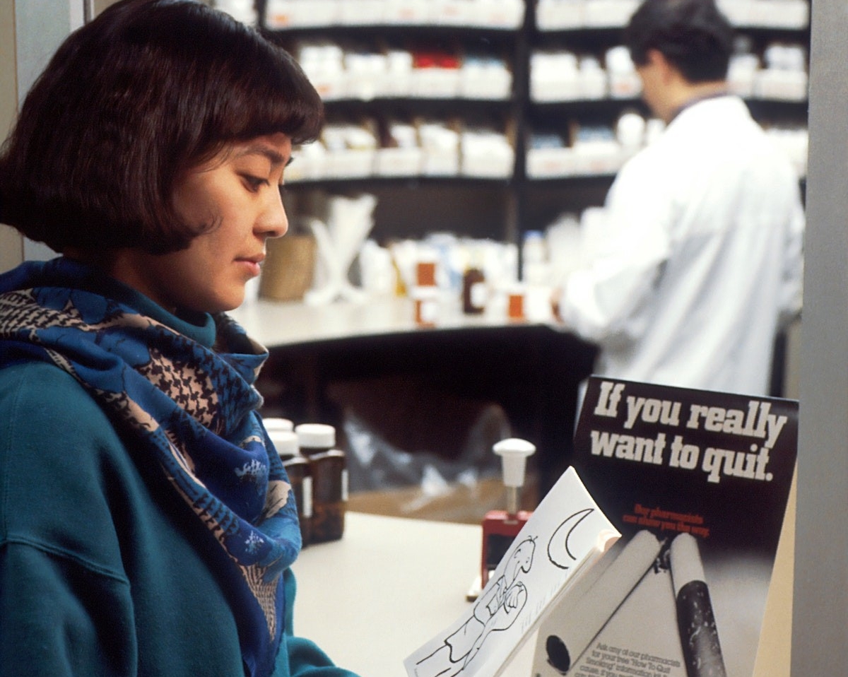 Woman reads a brochure about quitting smoking
