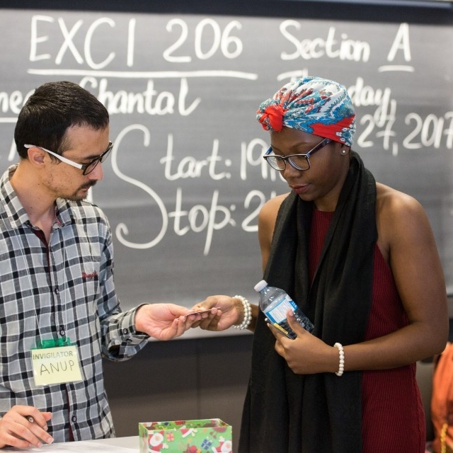 A student presents her identification to an exam invigilator