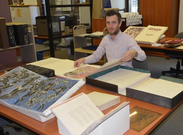 Geoffrey Little, collections librarian, thumbs through one of 11 rare books recently donated to Concordia