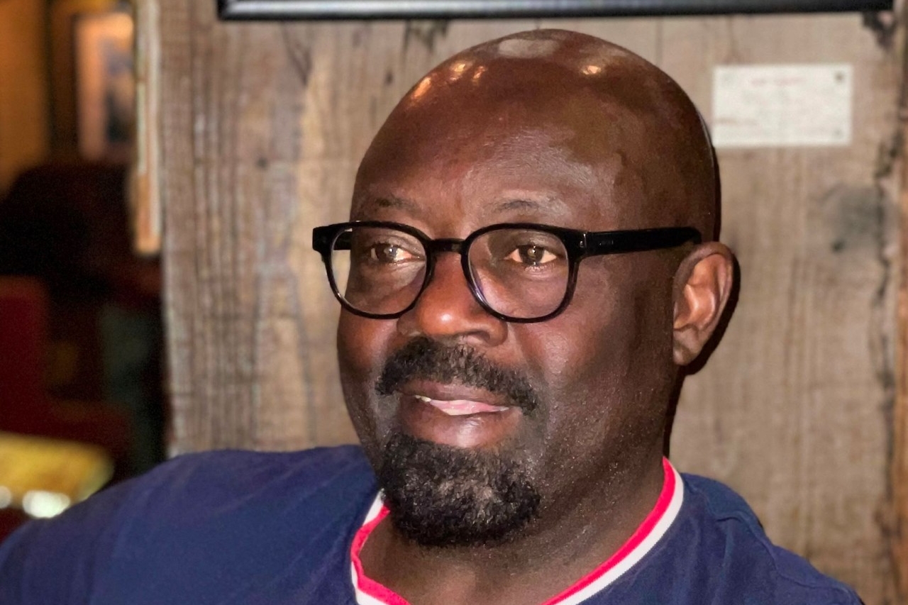 Paul Bandia A black man wearing glasses smiles.