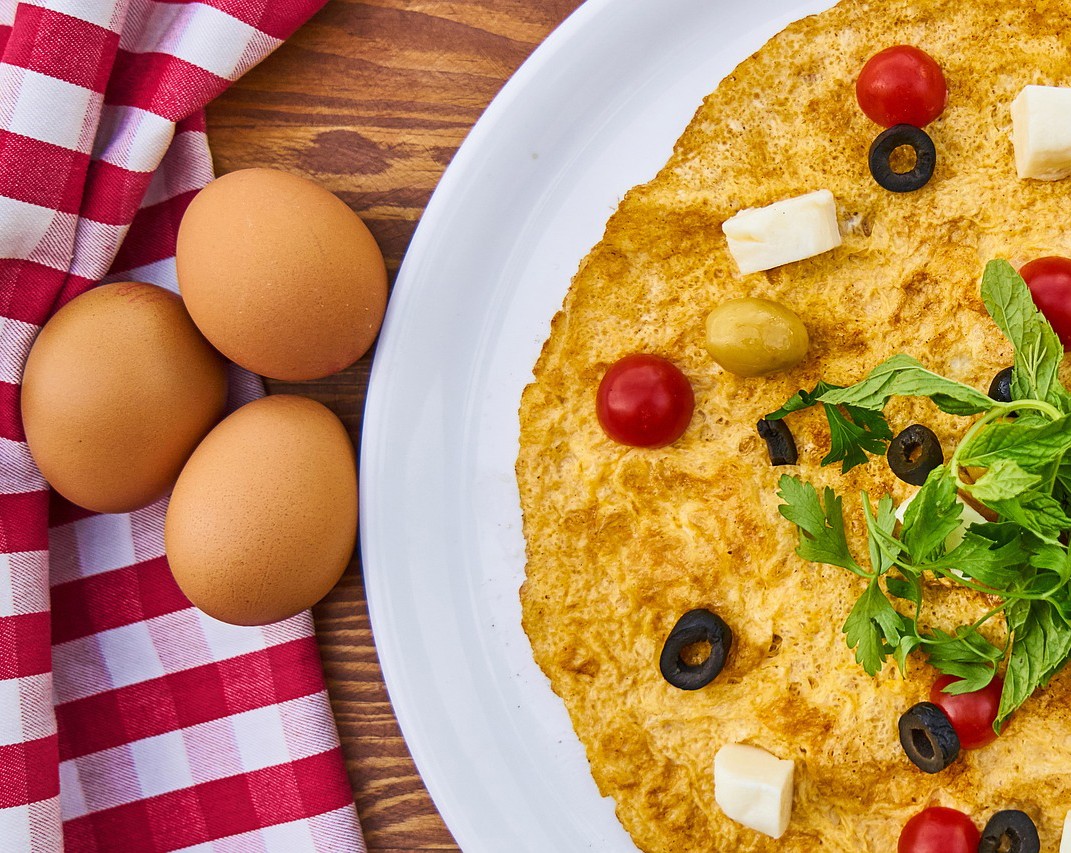 A healthy omelette with olives and greens