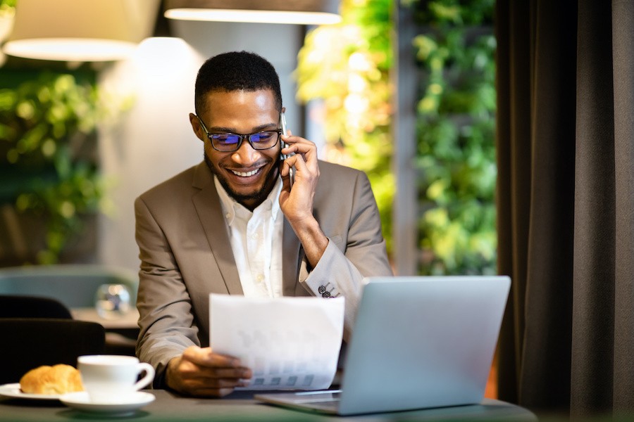 a man in an office talking on the phone and smiling