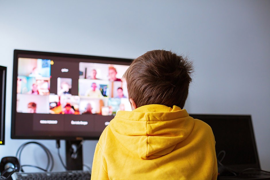 Teen at home having remote school on laptop computer 