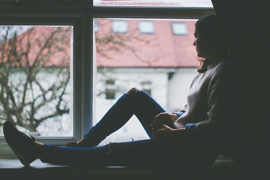 Depressed woman looking out the window