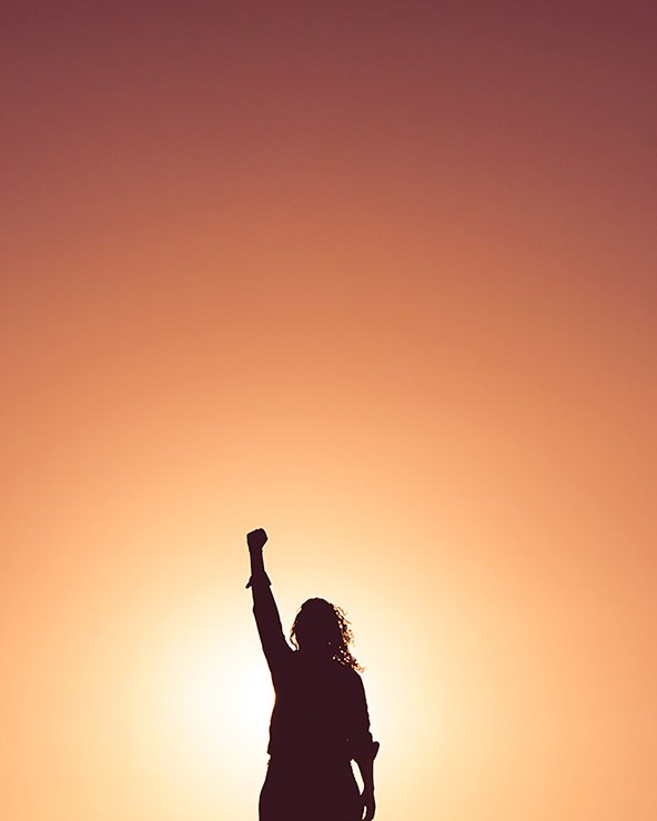 Silhouette of a person who raised one hand