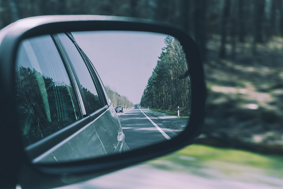 Side mirror of a car reflecting the road behind