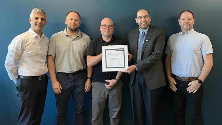 Five men line up and pose for a picture while accepting an award