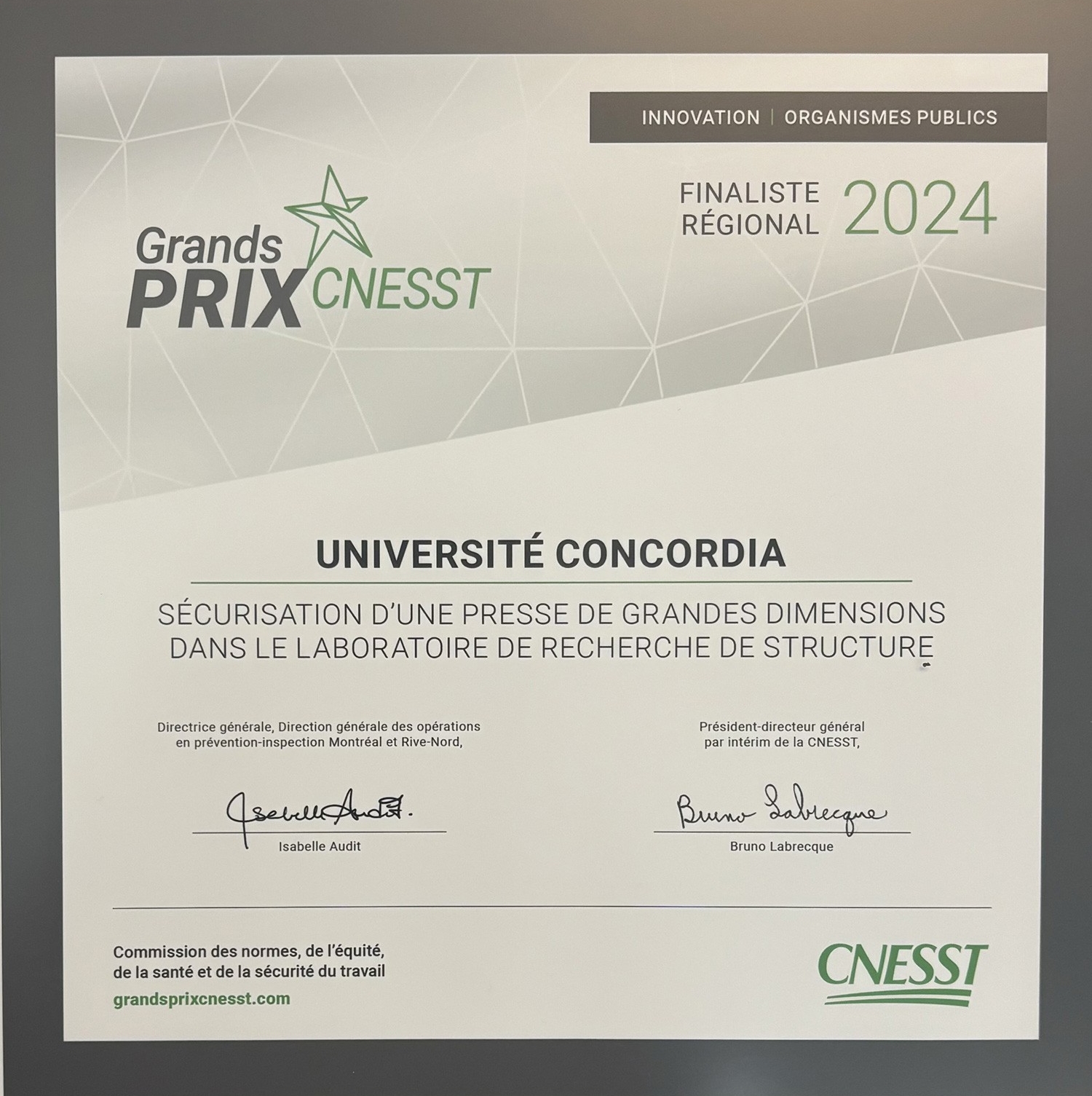 A framed certificate naming Université Concordia as a finalist for the CNESST Grands Prix 2024 for securing a high-capacity testing frame in a research lab.