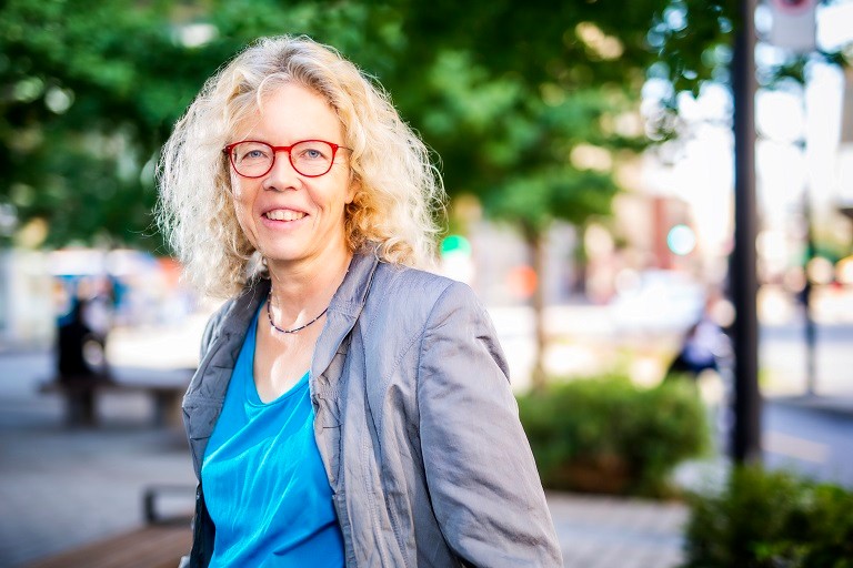 Woman with grey blazer and red eyeglasses