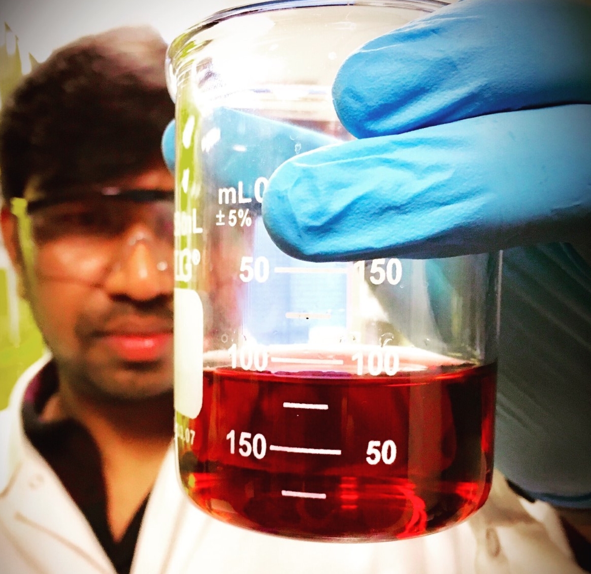 Srinivas Bathini holding a liquid vial in a lab