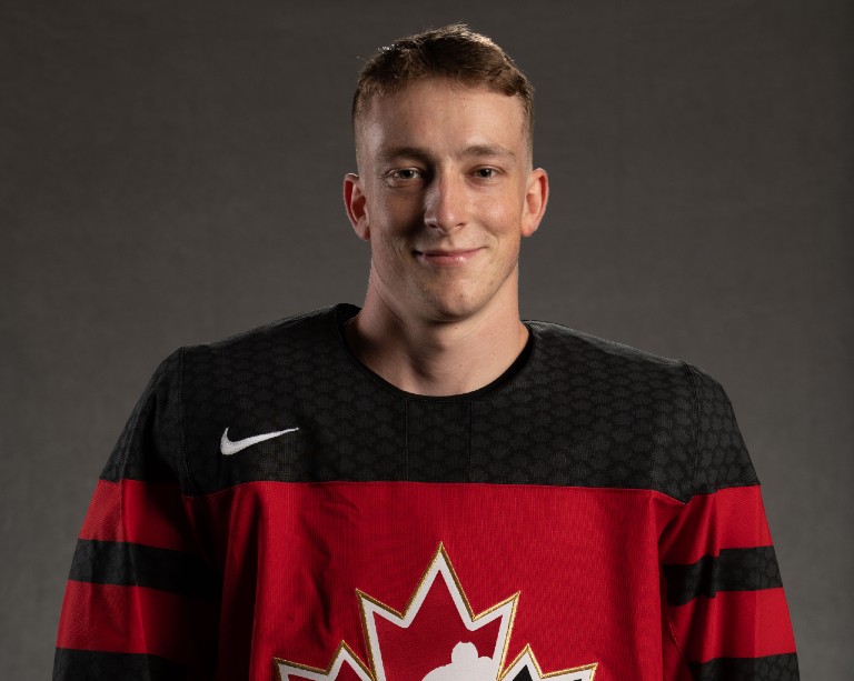 Hockey player headshot of smiling young man wearing black-and-red Team Canada jersey