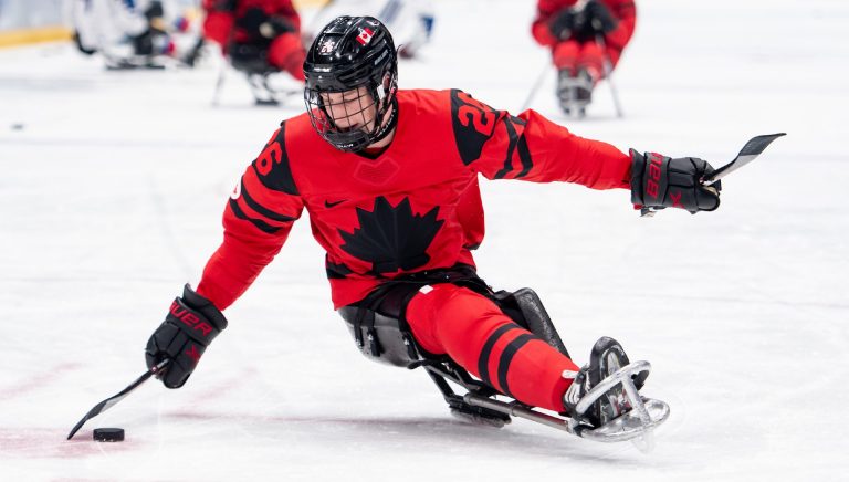 Joueur de hockey paralympique en uniforme rouge et noir sur la glace