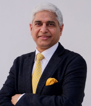 Smiling man with short, silver hair, wearing a suit jacket, shirt and tie.