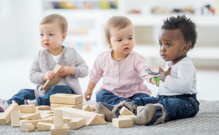 Trois bébés jouant avec des blocs
