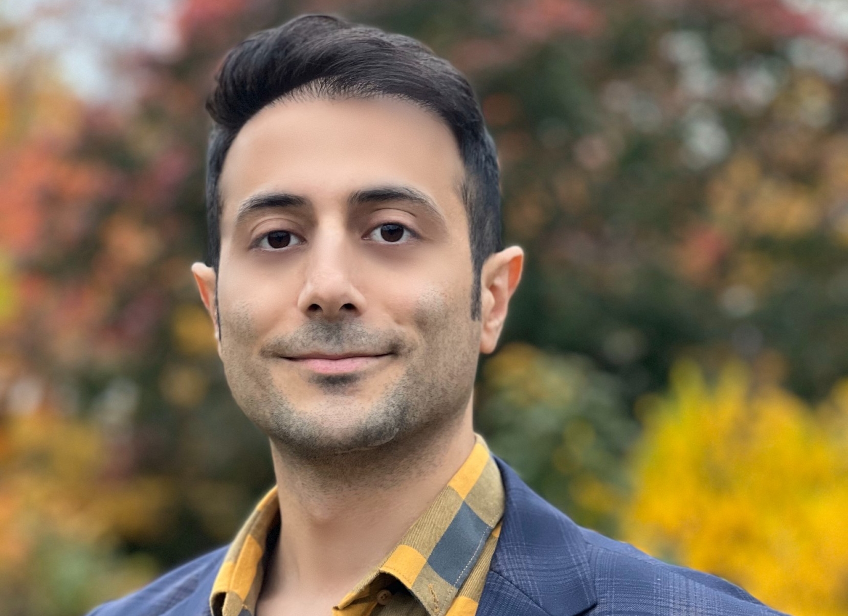 Navid Shirzadi Navid Shirzadi porte une veste bleue et une chemise jaune et bleue.