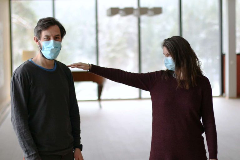Un homme et une femme portant un masque facial pratiquent la distanciation sociale