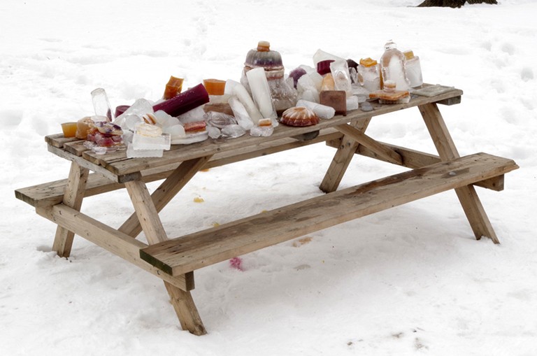 Zebras Collective, <em>And the suspicion arises that even the zebra was not designed for our benefit</em>, 2022-2024. | Photo : Yann-Marc Pignard Une table de pique-nique en plein air dans la neige, avec des sculptures de glace et d'agar-agar sur le dessus.