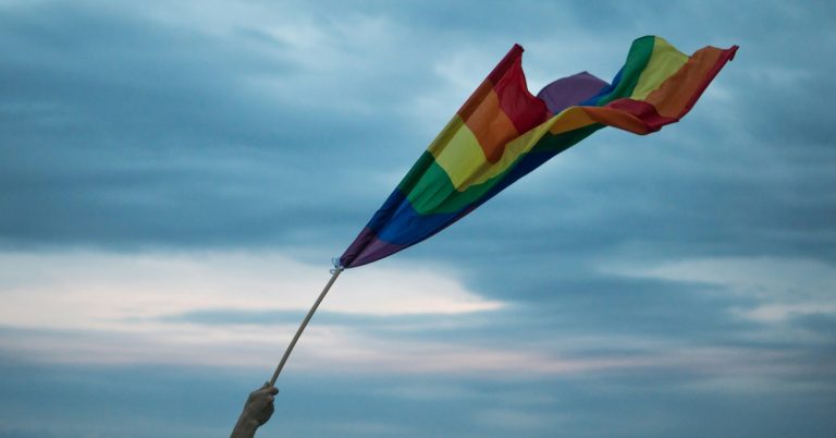 A pride flag waves in the air