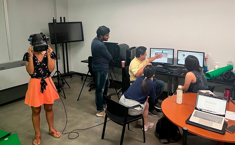 People in a space with computers and a someone wearing a VCR headset